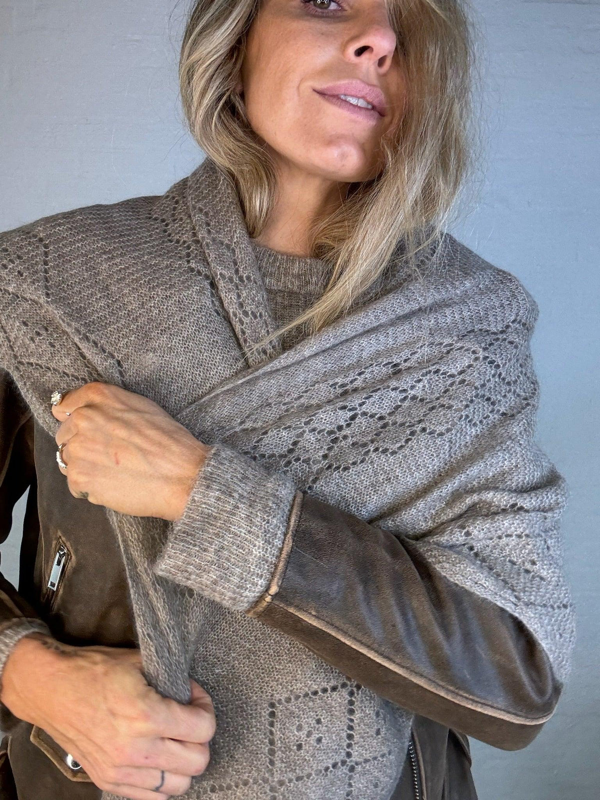 Kvinde iført Andcopenhagen Basics Triangle trinity cashmere tørklæde i khaki, stylet over en jakke.