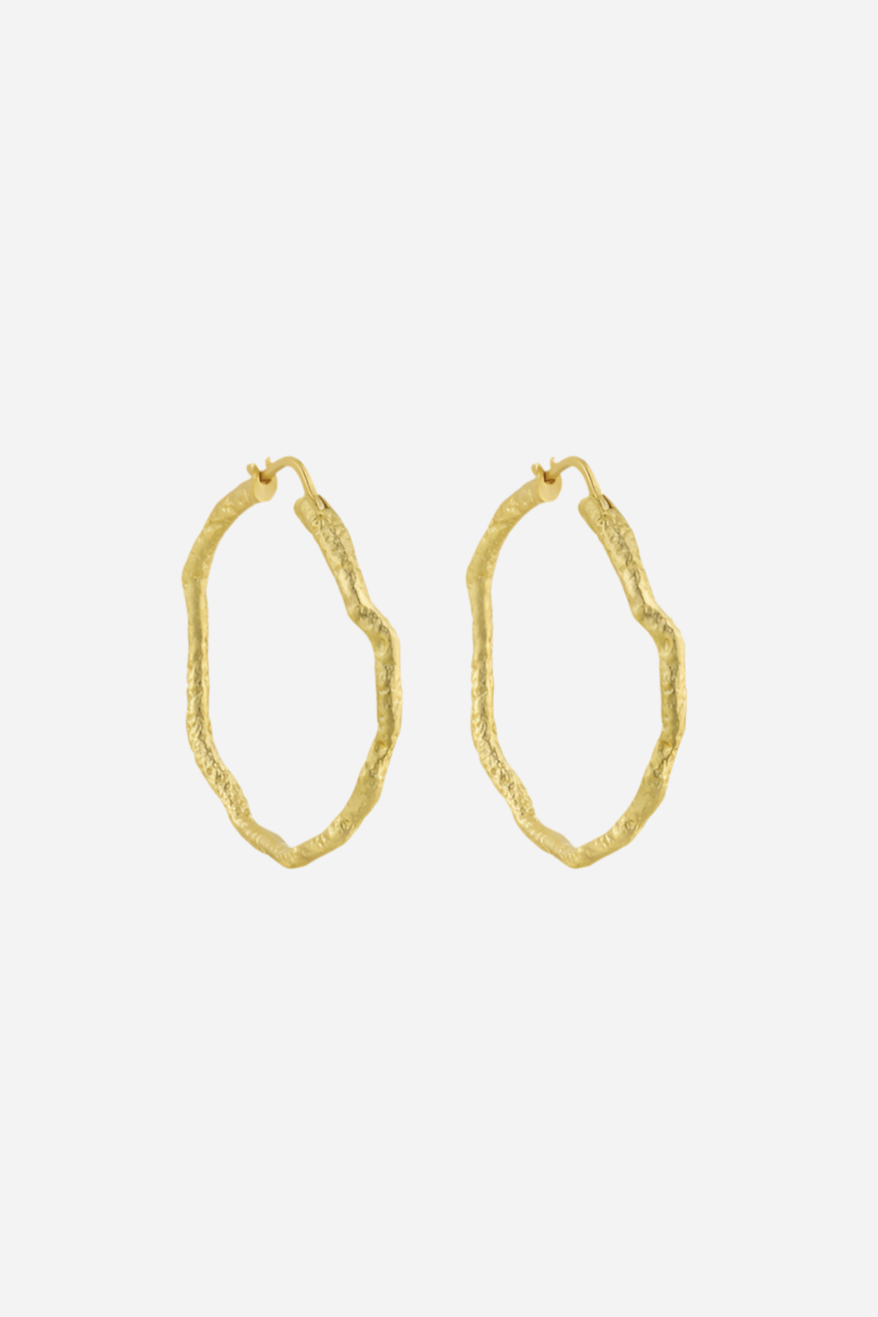 Teksturerede, organiske hoops i 18k guldbelagt sterlingsølv, fremhævet i nærbillede.