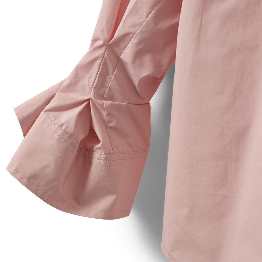 Lys pink skjorteærme med rynket manchet, viser tekstur og detaljer.