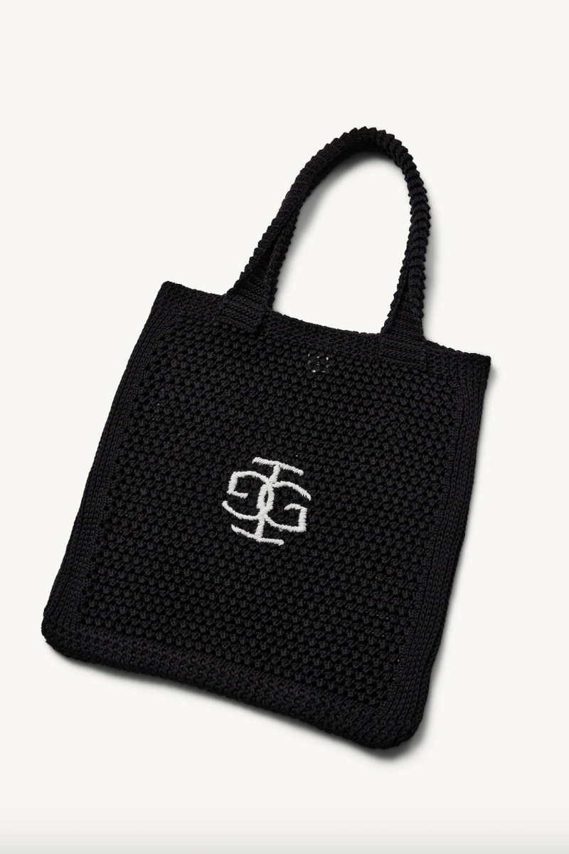 Sort tote bag med vævet tekstur og hvidt logo på forsiden.
