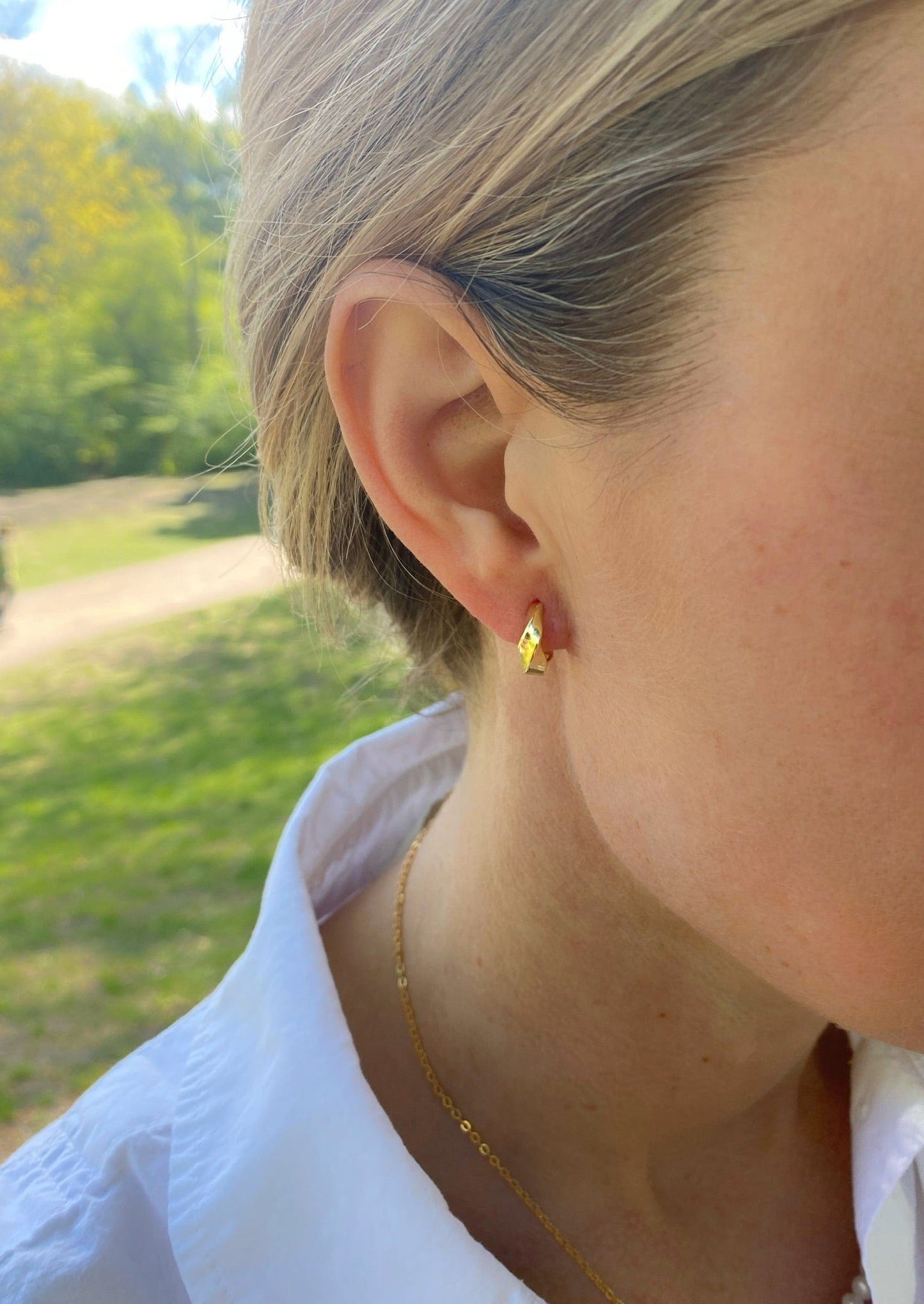 Kvinde bærer Andcopenhagen Jewelry Icon Collection øreringe hoops i 18 karat guldbelagt sterlingsølv.