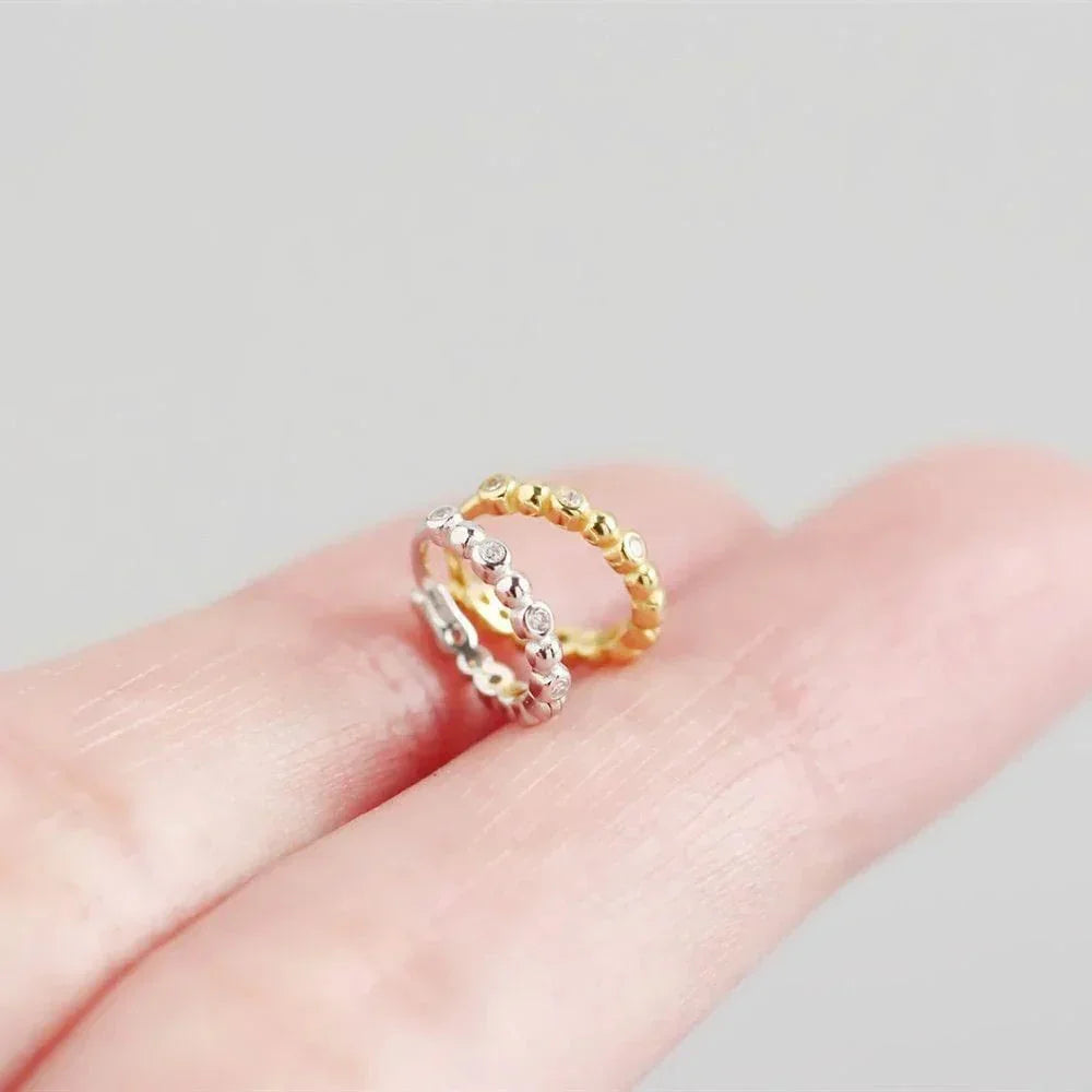 To hoops-øreringe, én i 18 karat guldbelagt sølv og én i sølv fra Andcopenhagen Vannie Shiny Dot.