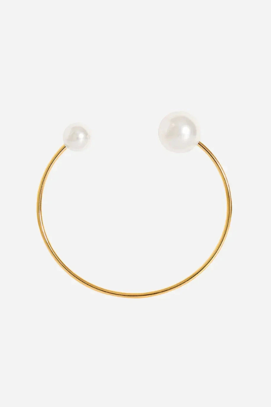 Minimalistisk bangle i guldbelagt stål med en hvid perle i hver ende.