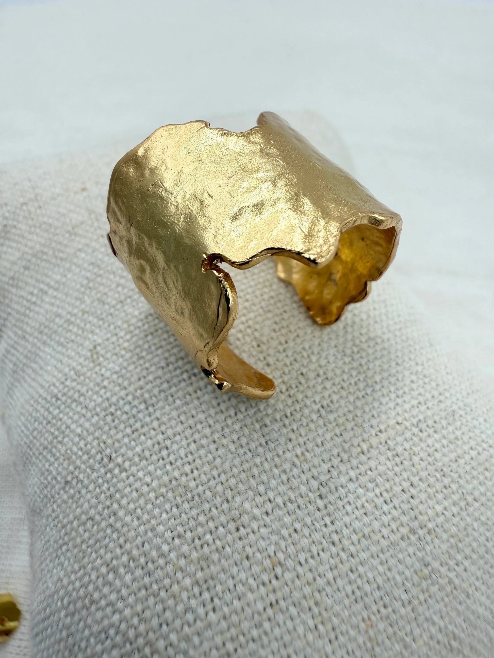 Ring med uregelmæssig, organisk form i 18 karat guldbelagt messing på tekstureret stof.