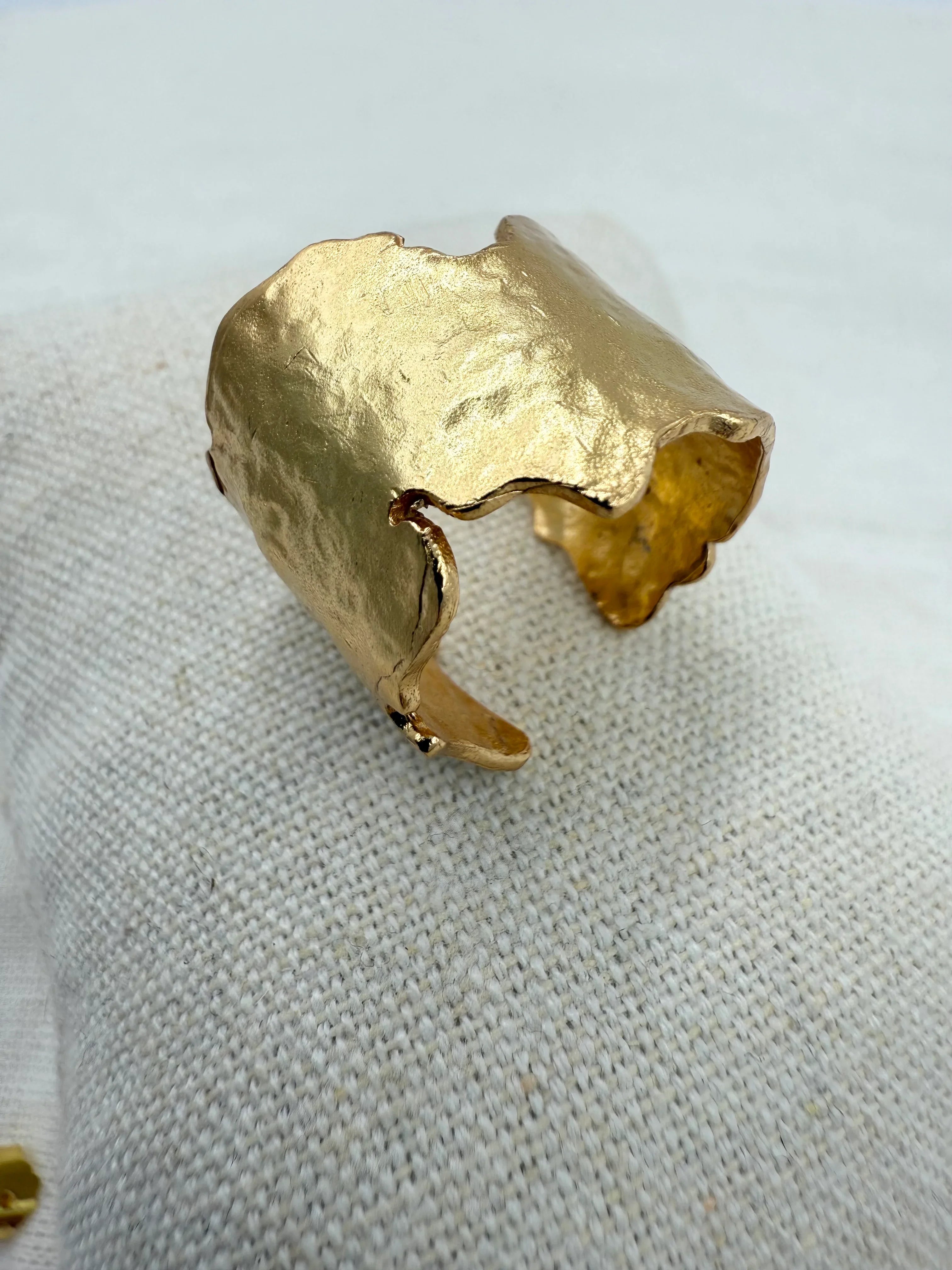 Ring med uregelmæssig, organisk form i 18 karat guldbelagt messing på tekstureret stof.