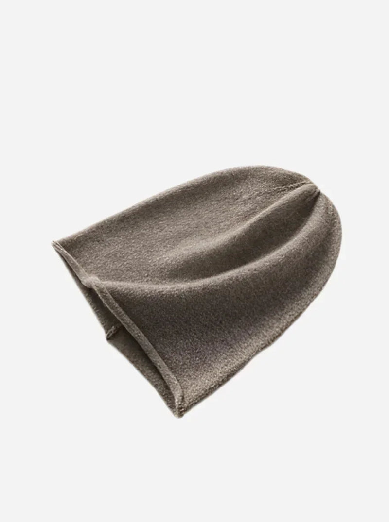 Kaffebrun cashmere beanie hat, fladt liggende, viser form og blød tekstur.