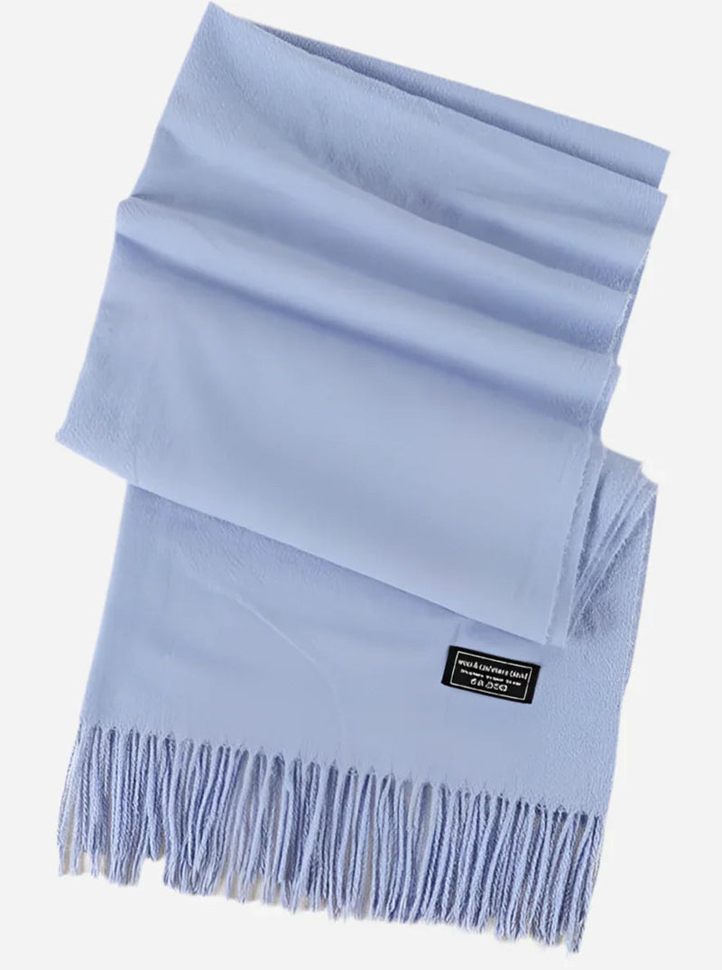 Lyseblåt cashmere tørklæde fra Andcopenhagen Basics med frynser og mærket “Yana” på produktets etiket.