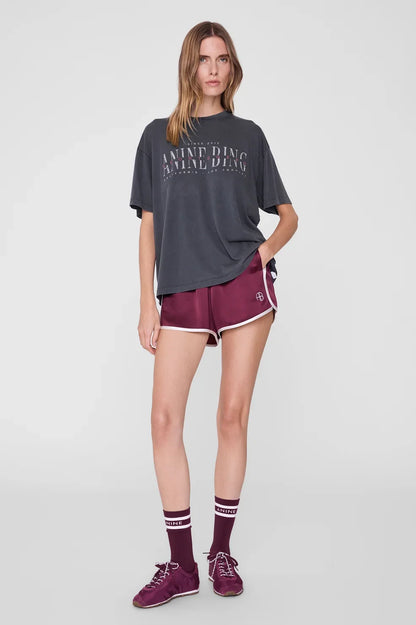 Cade Tee Sport Club fra Anine Bing er en cool og afslappet T-shirt, der kombinerer et sporty udtryk med brandets karakteristiske vintage-stil.