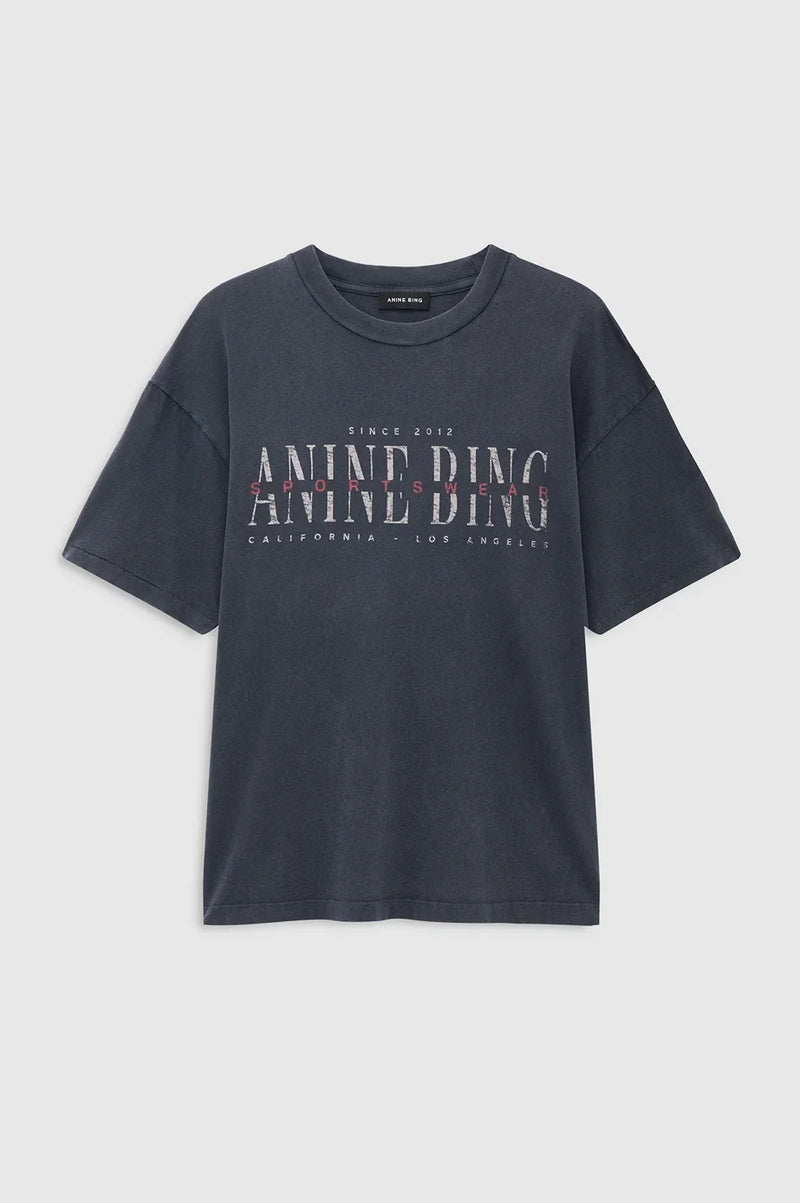 Cade Tee Sport Club fra Anine Bing er en cool og afslappet T-shirt, der kombinerer et sporty udtryk med brandets karakteristiske vintage-stil.