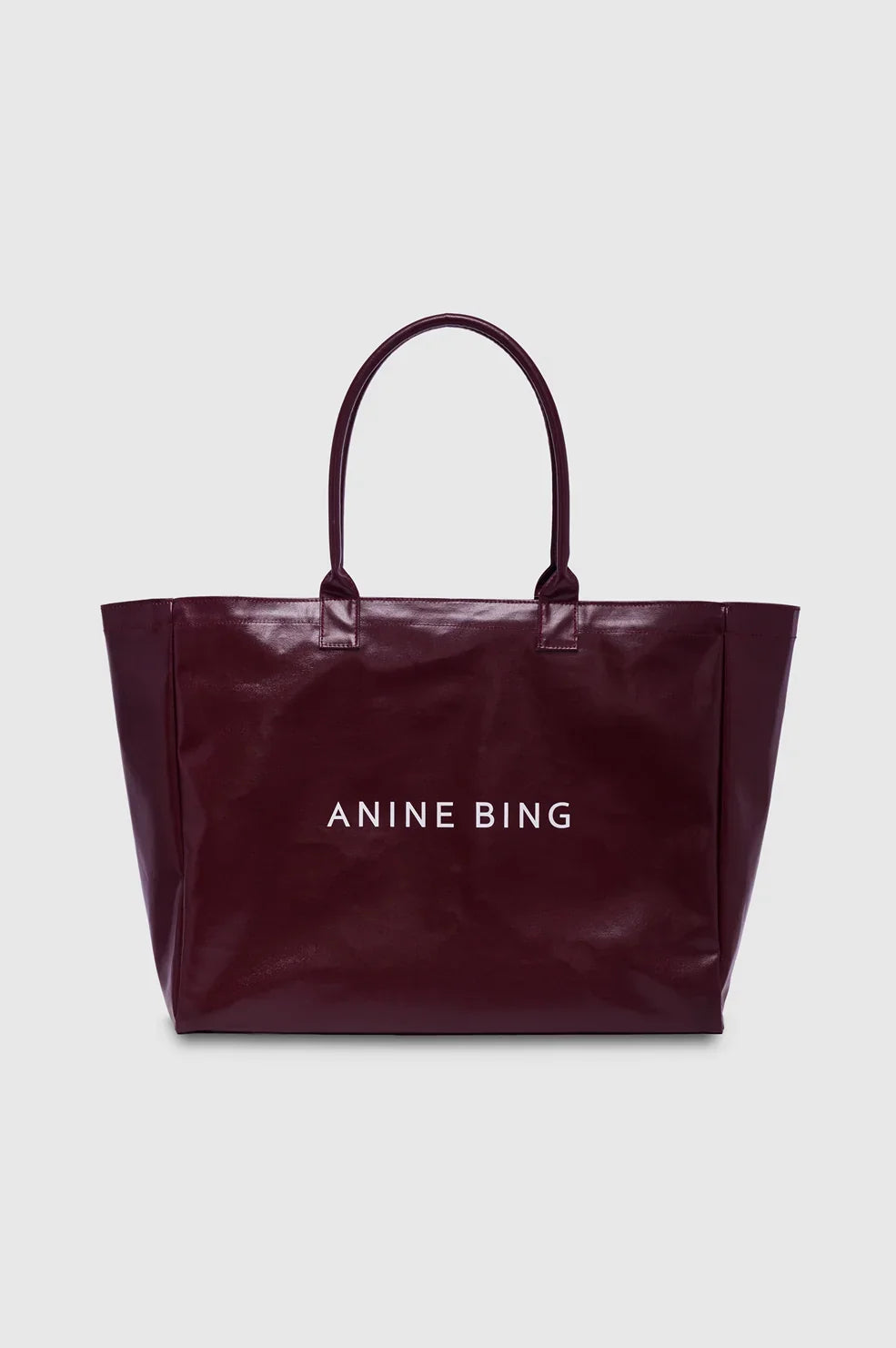 ANINE BING Leo Coated Canvas Tote i dyb bordeaux (Fig) med stort kontrastfarvet logo på fronten og lange skulderstropper packshot