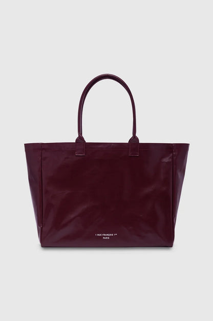 ANINE BING Leo Coated Canvas Tote i dyb bordeaux (Fig) med stort kontrastfarvet logo på fronten og lange skulderstropper bagfra