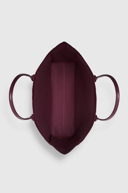 ANINE BING Leo Coated Canvas Tote i dyb bordeaux (Fig) med stort kontrastfarvet logo på fronten og lange skulderstropper oppefra