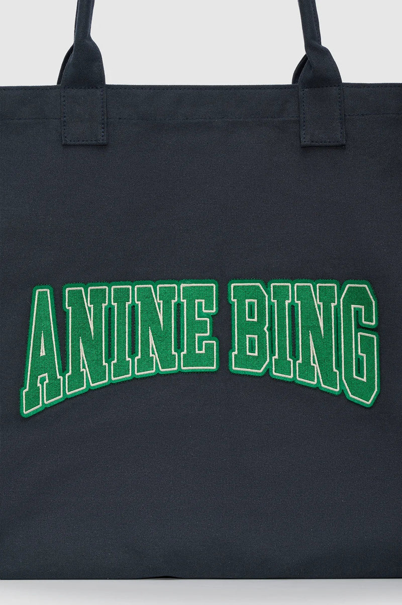 ANINE BING Leo Canvas Tote i vasket sort bomuldscanvas med grønne detaljer, broderet logo på fronten og lange skulderstropper tæt på logo