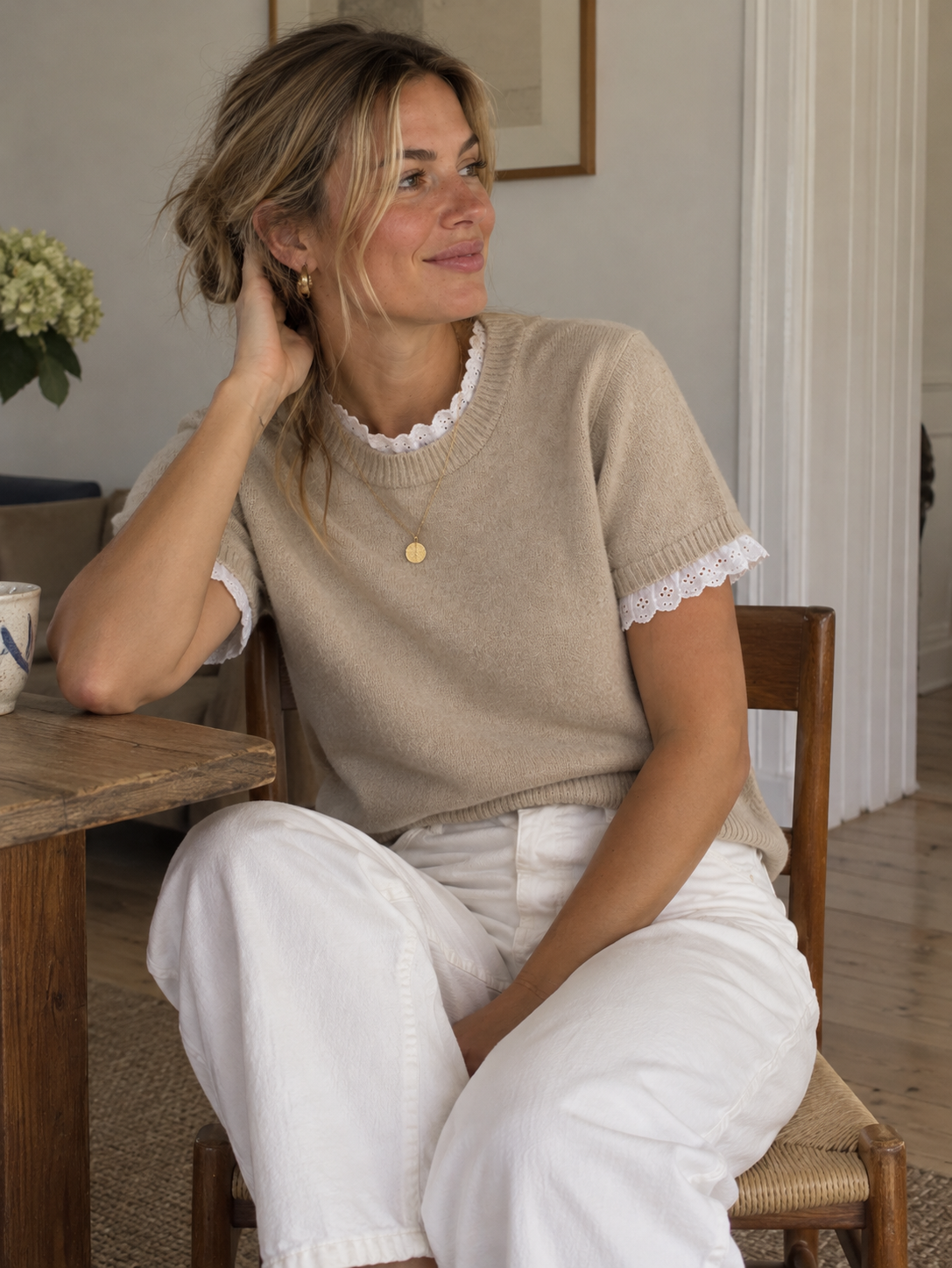 Nirvana er en feminin og stilfuld strikbluse, der kombinerer et klassisk design med romantiske detaljer