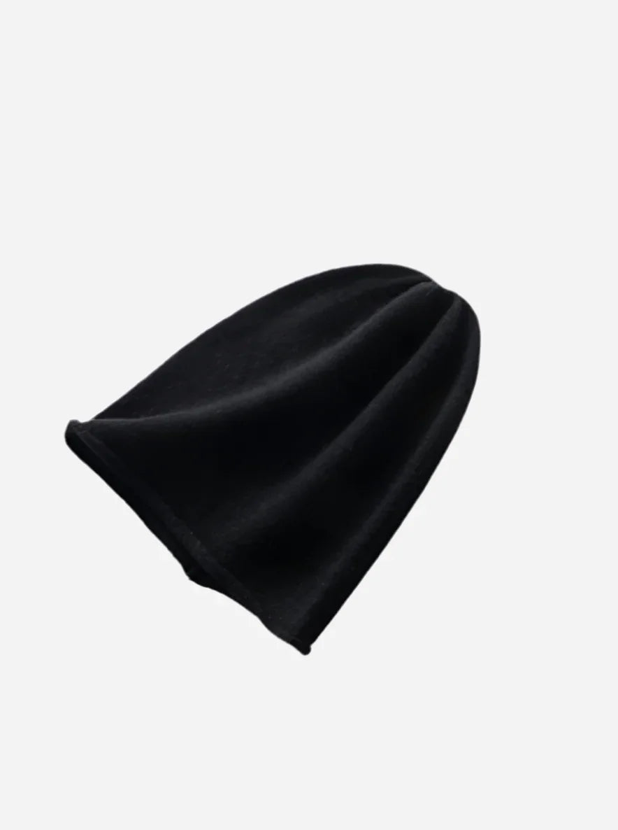 Sort beanie-hat i 100% cashmere med glat tekstur og enkelt design.