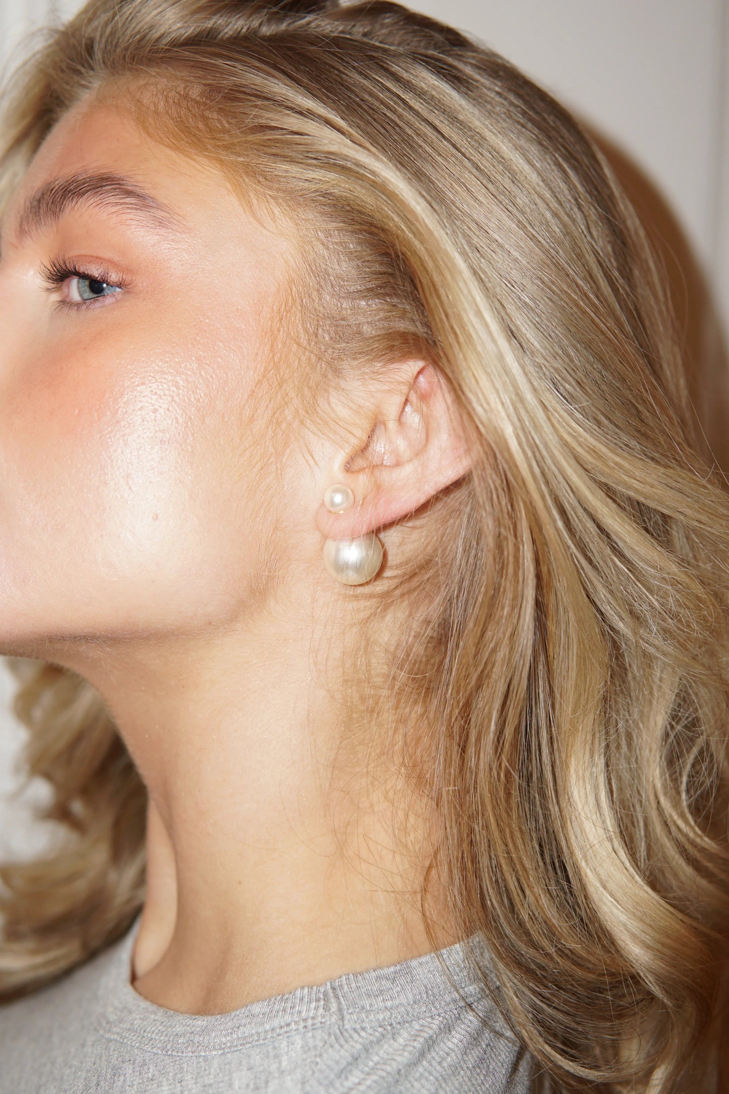Kvinde med Sophie double pearl øreringe fra Andcopenhagen Jewelry, vist på øret.
