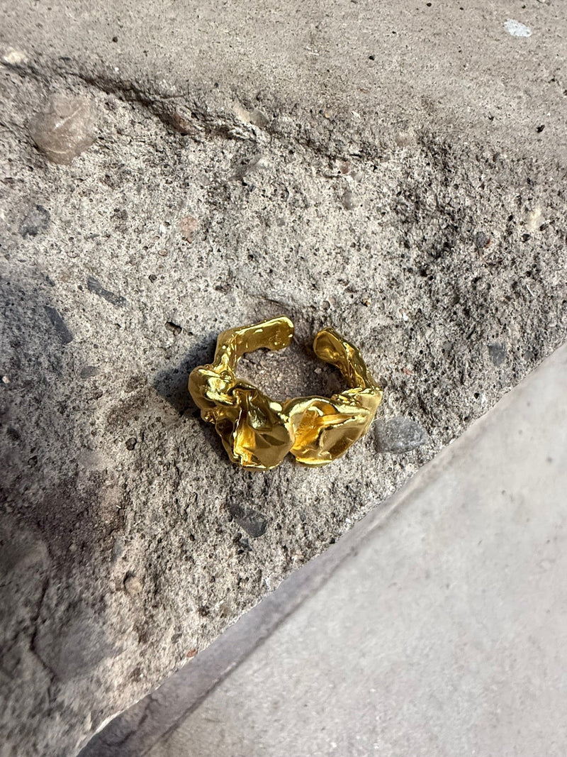 Arlinda ring i 18 karat guldbelagt 925 sterlingsølv fra Andcopenhagen Jewelry på betonbaggrund.