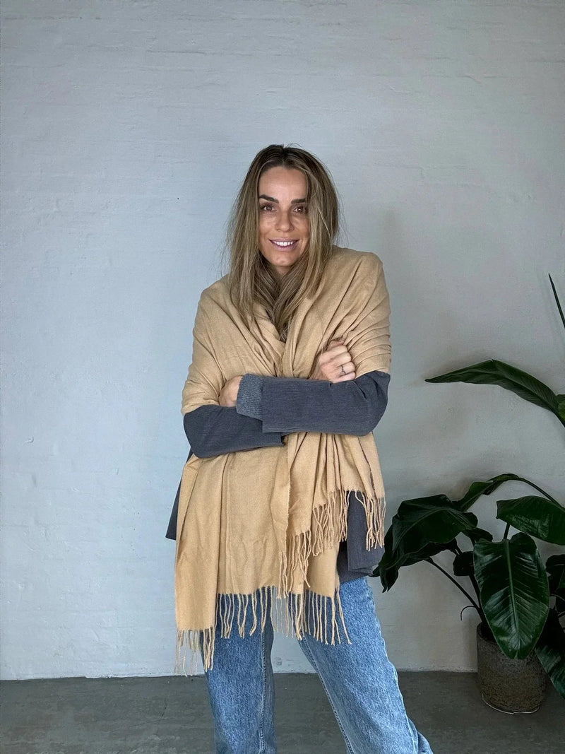 Kvinde iført Andcopenhagen Basics cashmeretørklæde i sandfarve, 70% cashmere, model Yana.