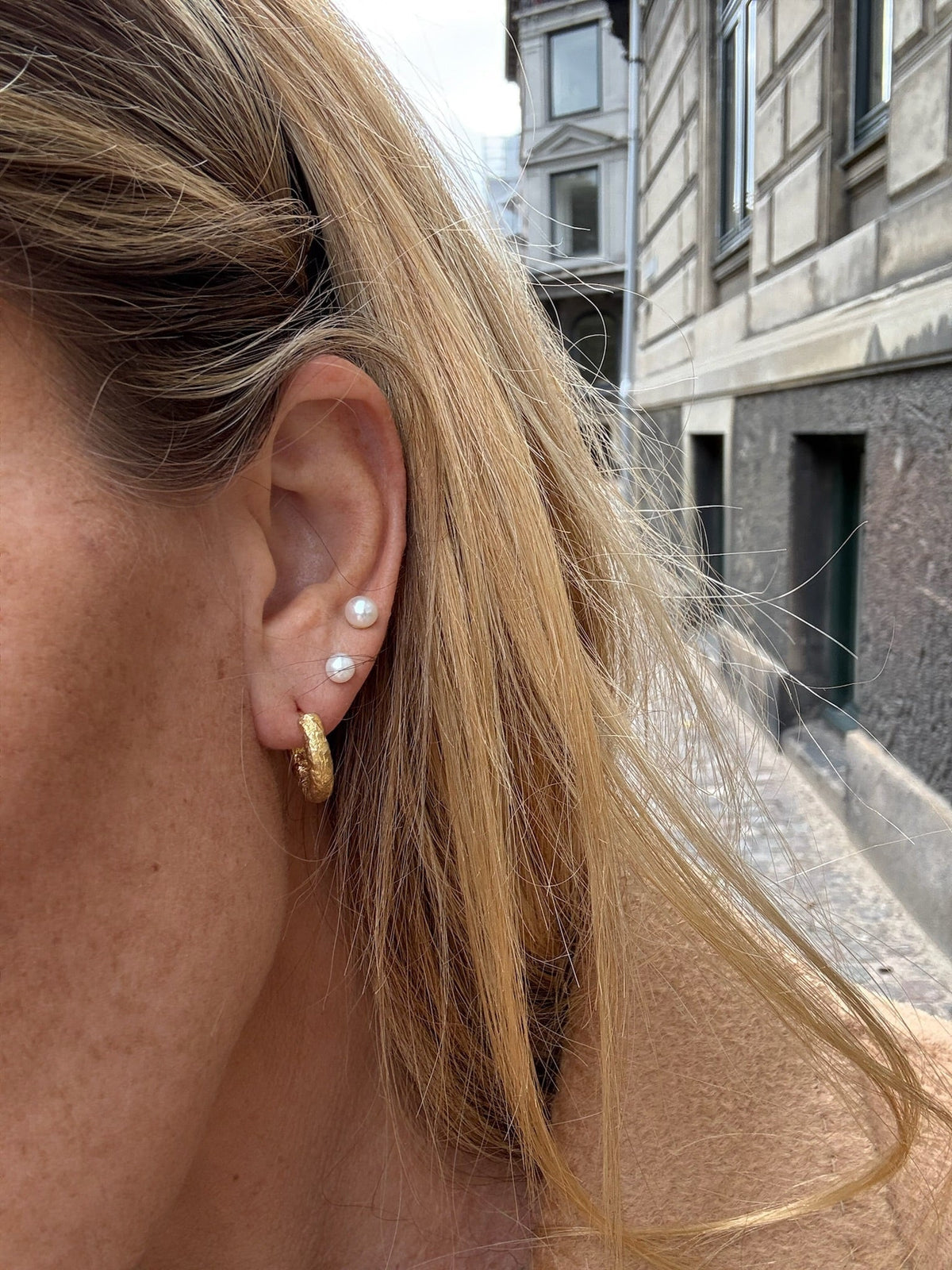Nina chunky øreringe hoops i 18 karat guldbelagt messing fra Andcopenhagen bæres af model.