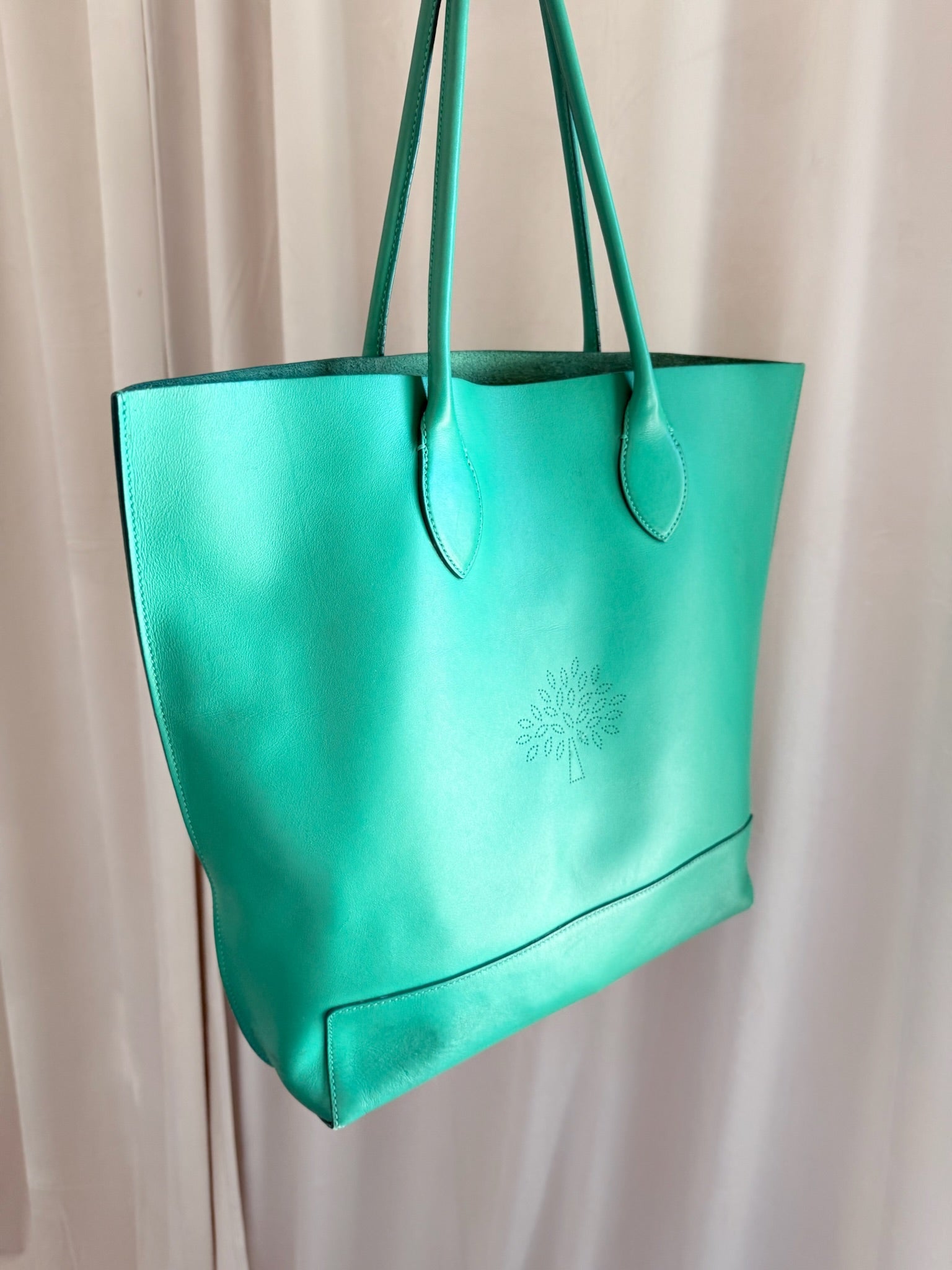 Grøn Mulberry Nappa tote bag med trælogo og glat overflade. Lang hank, lys baggrund.