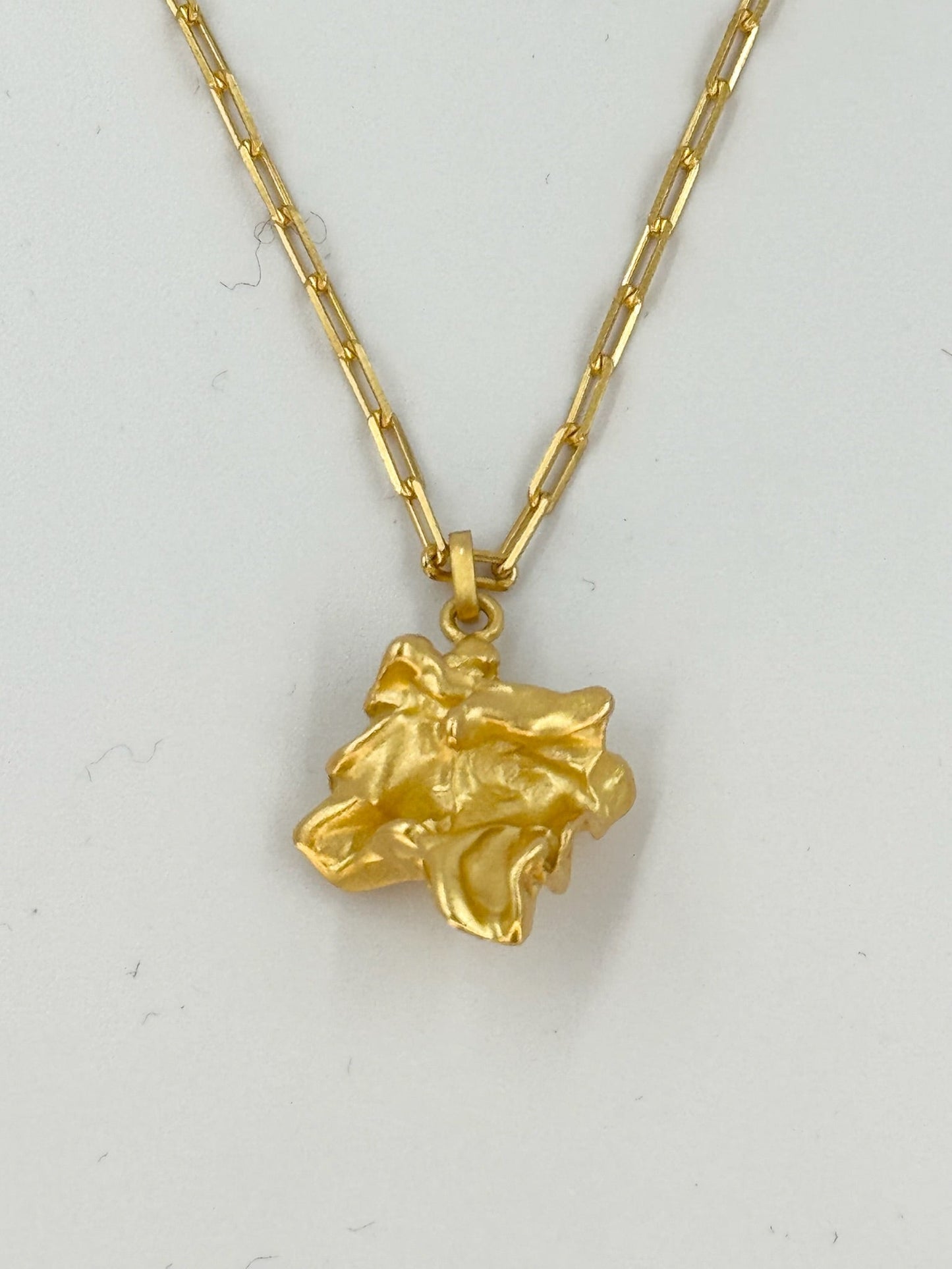 Halskæde i 18 karat guldbelagt sølv med organisk vedhæng og flade led.