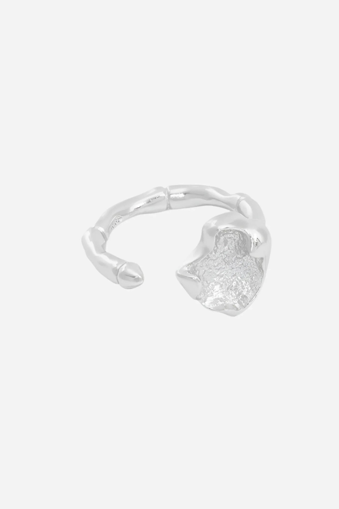 Sølvfarvet justerbar ring med bølget design og tekstureret overflade, vist på en hånd.