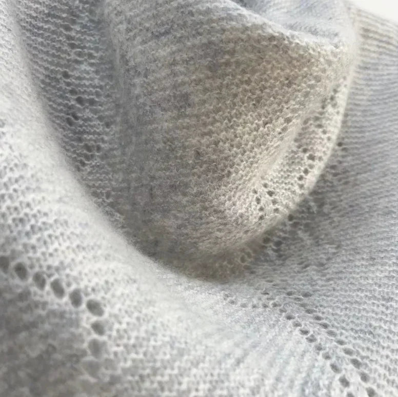 Detalje af gråt cashmeretørklæde fra Andcopenhagen Basics, trekantet og strikket i 100% cashmere.