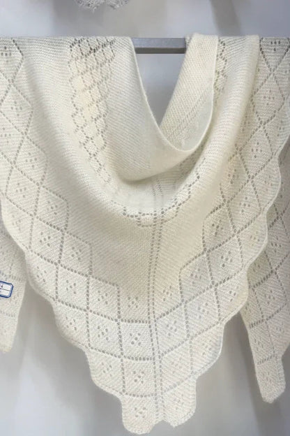 Hvidt trekantet cashmeretørklæde med hulmønster, udstillet på bøjle. 100% cashmere.
