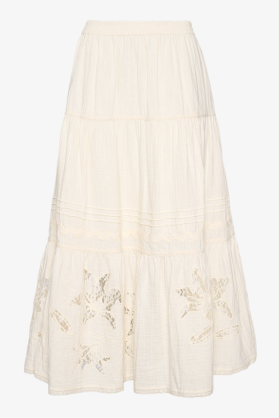 Off-white nederdel med etager og blomsterudskæringer nederst.