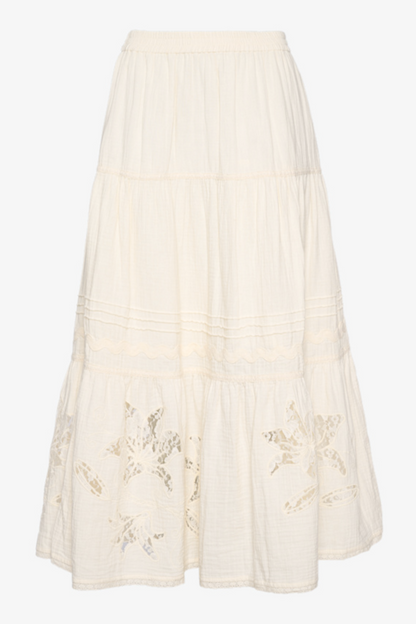 Off-white nederdel med etager og blomsterudskæringer nederst.