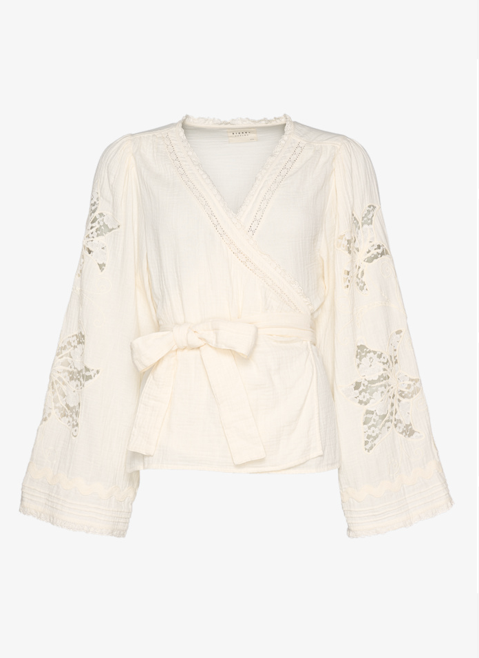 Hvid wrap-bluse med blonder, brede ærmer og bindebånd i taljen fra Sissel Edelbo.