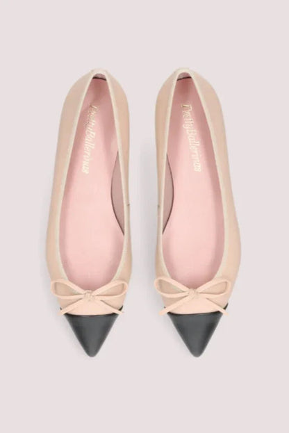 Elegante beige ballerinasko med sort spids tå, dekorativ sløjfe og flad sort sål.