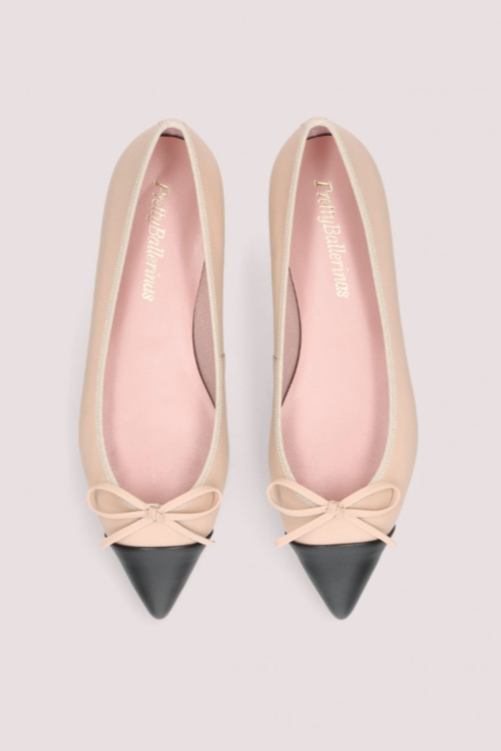 Elegante beige ballerinasko med sort spids tå, dekorativ sløjfe og flad sort sål.