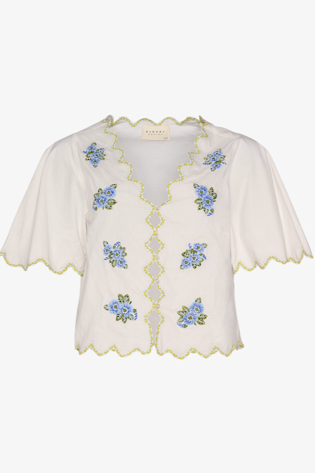 Skjorte med blå blomsterbroderi, grønne kantsøm og korte ærmer.
