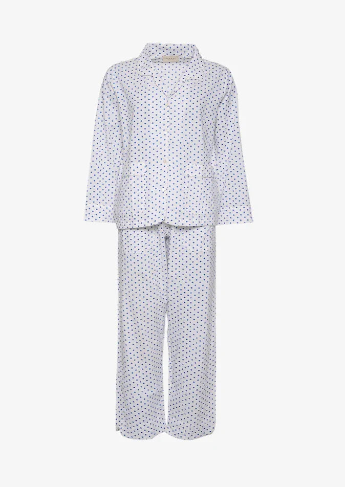 Hvid nattøjssæt med marineblå prikker, langærmet skjorte og bukser.