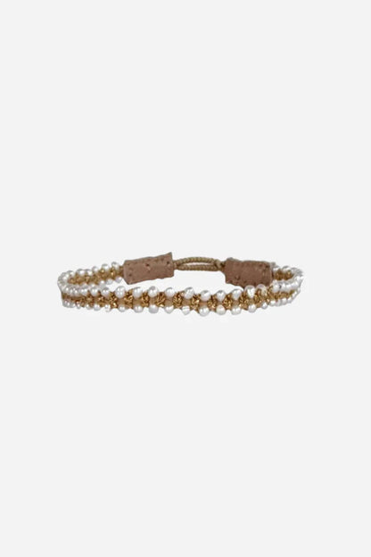 Armbånd med hvide og guldperler i to rækker, justerbar snor-lukning, elegant design.