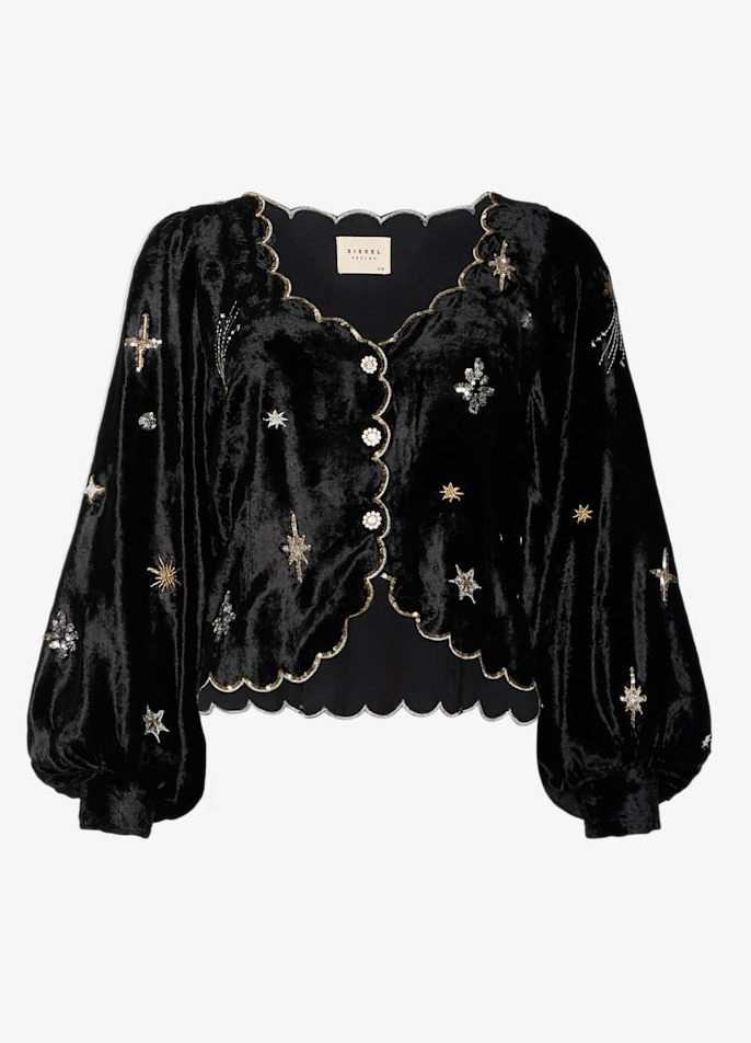 Sort bluse med skinnende stof, broderede stjerner, bølget kant og knapper foran.