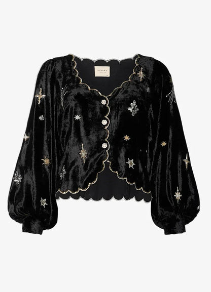 Sort bluse med skinnende stof, broderede stjerner, bølget kant og knapper foran.