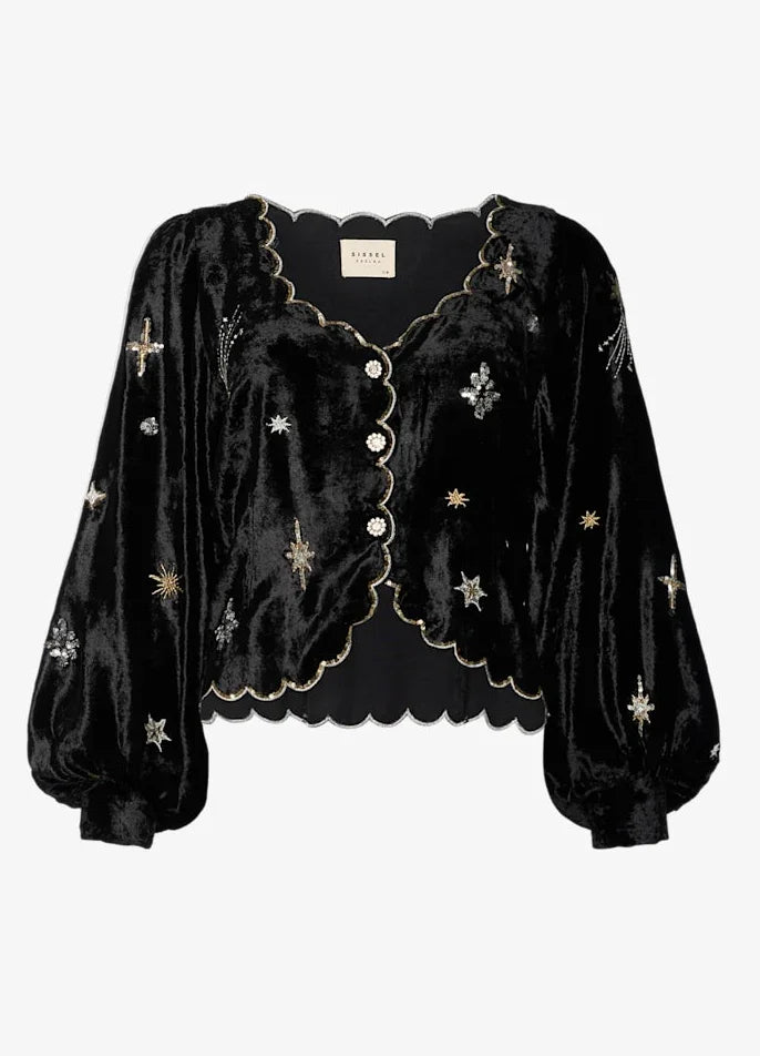 Sort bluse med skinnende stof, broderede stjerner, bølget kant og knapper foran.