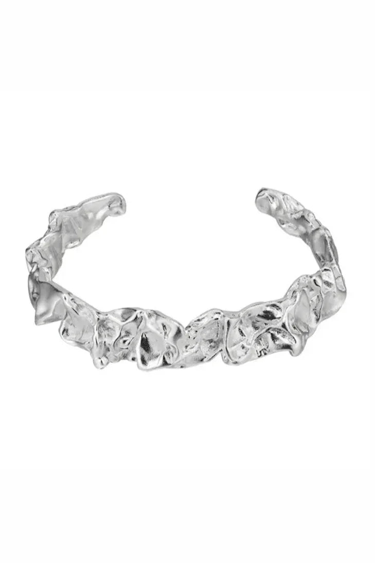 Armbånd i åbent manchet-design med unik, tekstureret overflade. Justerbar til forskellige størrelser.