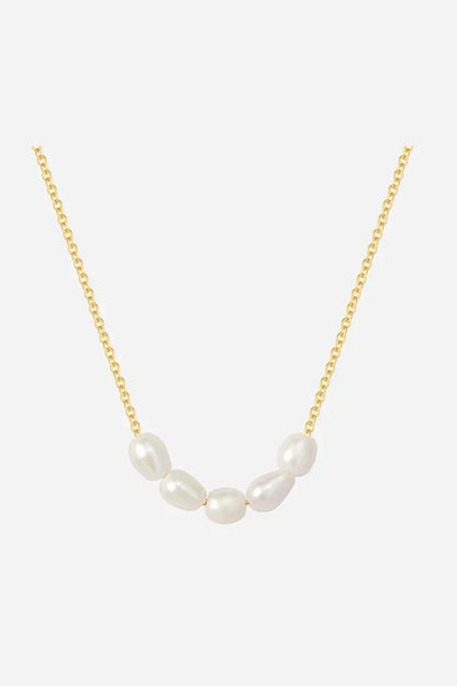 Halskæde med guldbelagt kæde og buet række af uens perler i forskellige størrelser og former.
