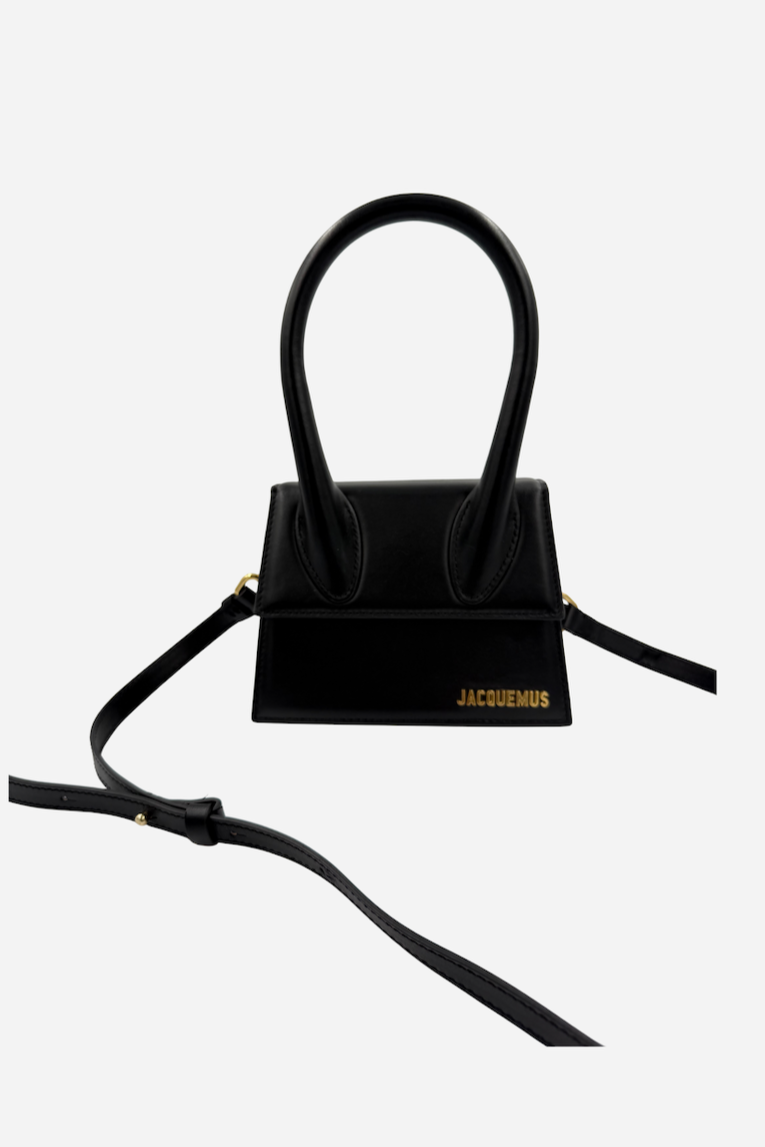 Sort Jacquemus "Le Chiquito" taske med to håndtag, guldlogo og blank overflade.