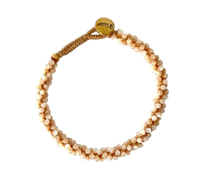 Armbånd med vævede perlelignende perler, cirkulær form, gylden knaplukning.