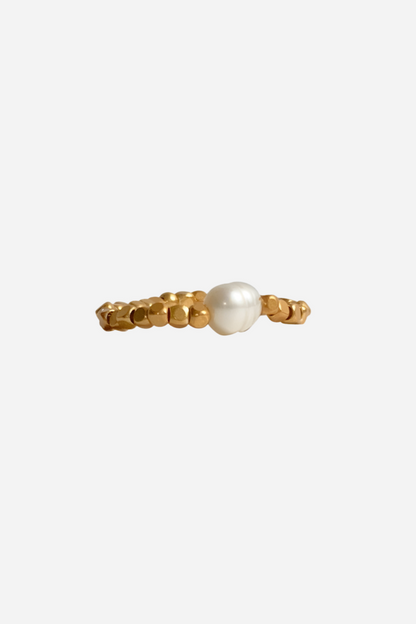 Håndlavet ring med guldfarvede perler og en central hvid perle, organisk og unik design.