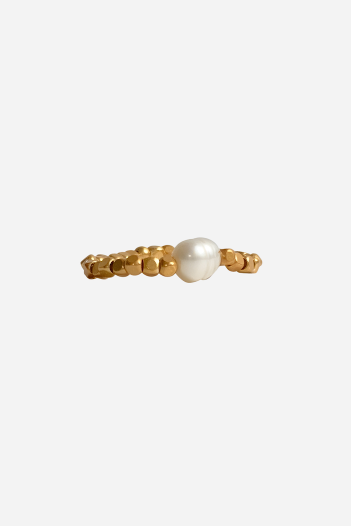 Håndlavet ring med guldfarvede perler og en central hvid perle, organisk og unik design.