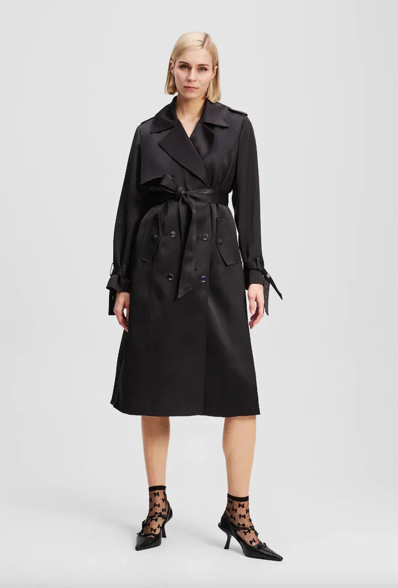 Sort trenchcoat med bred krave, bælte, dobbeltradet knaplukning og plisseret detalje bagpå.