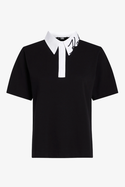 Sort polo med hvid krave, signaturdetalje på kraven, og korte ærmer.