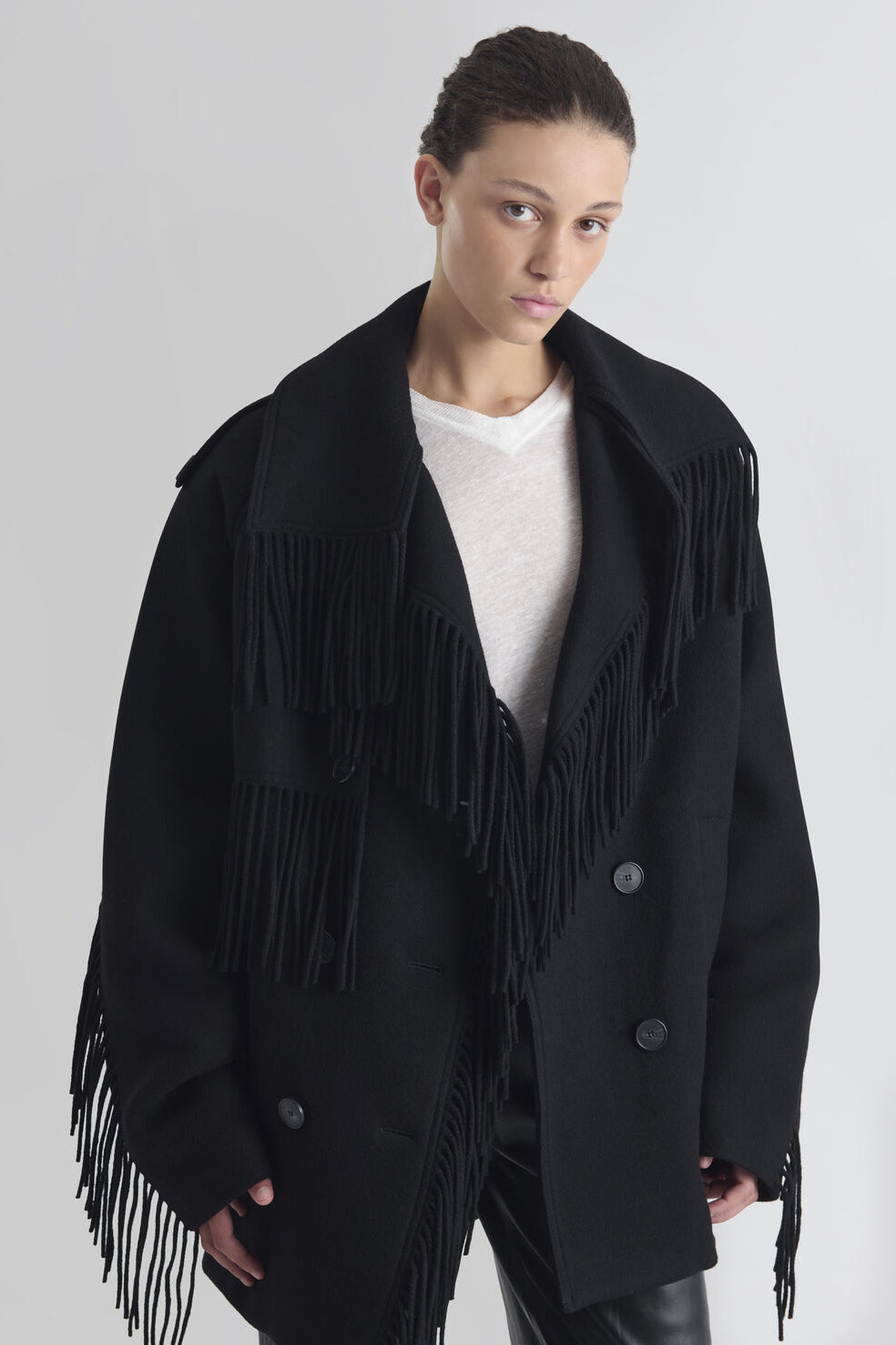 Sort oversized IRO Paris Drifter uldjakke med frynser langs krave, front og ærmer, bred reverskrave og dobbeltradet knaplukning.