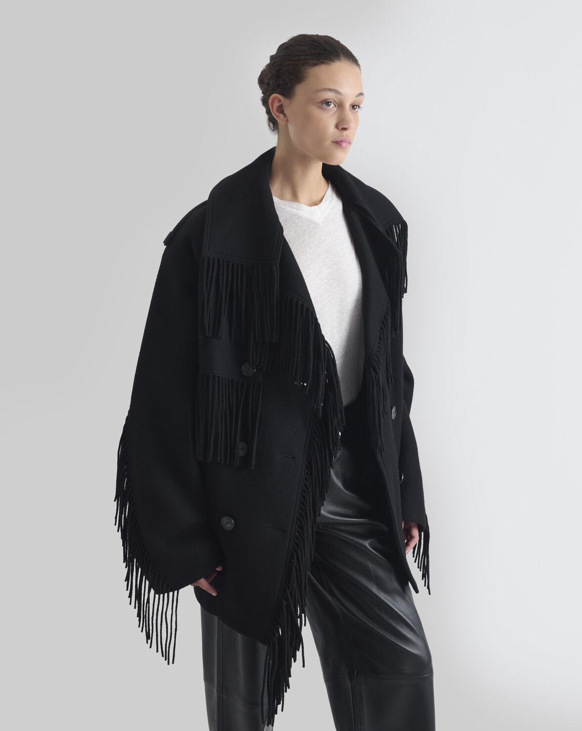 Sort oversized IRO Paris Drifter uldjakke med frynser langs krave, front og ærmer, bred reverskrave og dobbeltradet knaplukning fra siden